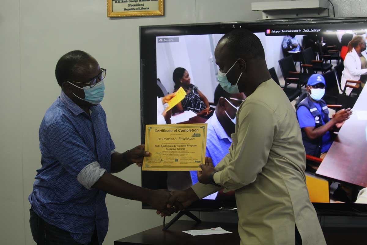 Dr. Francis Kateh, Chief Medical Officer, Liberia presenting certificate to Dr. Romaric Agossou Tandjiekpon (FETP-E Cohort 1 graduate)